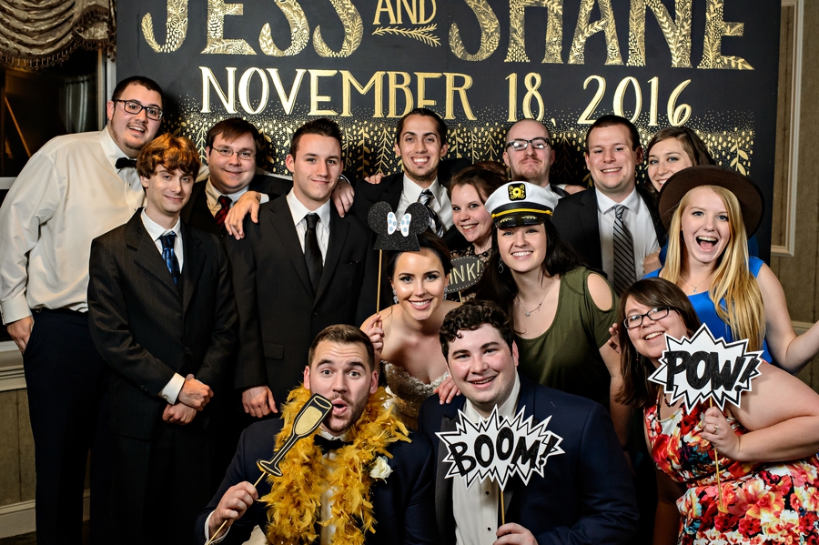 A wedding party jump into a gold photo booth.